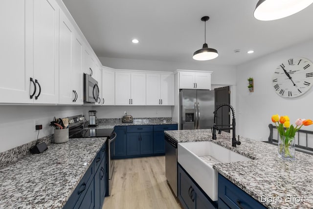412 S Woodworth St, Corunna, MI 48817 - kitchen with appliances with stainless steel finishes, blue cabinets, white cabinetry, light wood finished floors, and light stone countertops