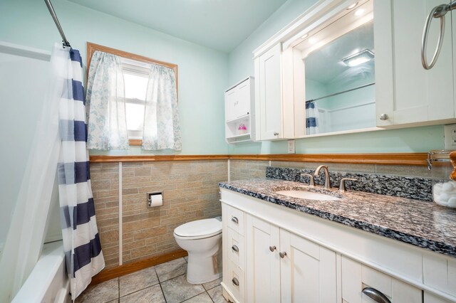 275 Benjamin St, Benton Harbor, MI 49022 - bathroom with vanity, tile walls, tile patterned floors, a wainscoted wall, and shower / bath combo with shower curtain