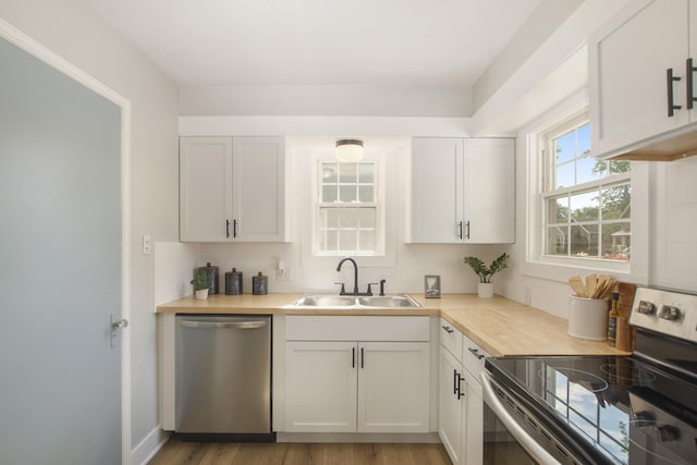 185 W 21st St, Holland, MI 49423 - kitchen with stainless steel appliances, light countertops, light wood-style flooring, and white cabinets