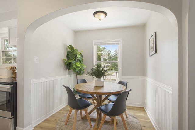 185 W 21st St, Holland, MI 49423 - dining space with a wainscoted wall, light wood-type flooring, and arched walkways