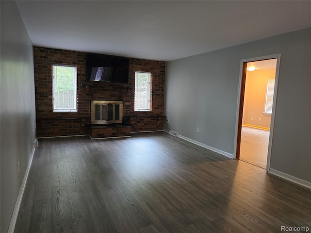 22024 Lester St, Clinton Township, MI 48035 - unfurnished living room with dark wood-style flooring, plenty of natural light, and brick wall