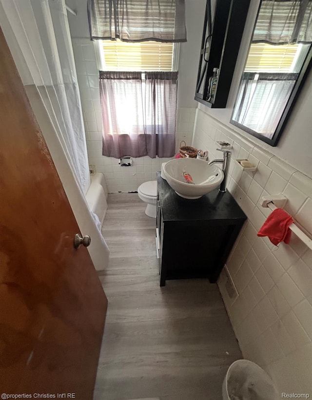 14633 College Ave, Dearborn, MI 48101 - full bathroom with tile walls, wood finished floors, vanity, a wainscoted wall, and shower / bath combo