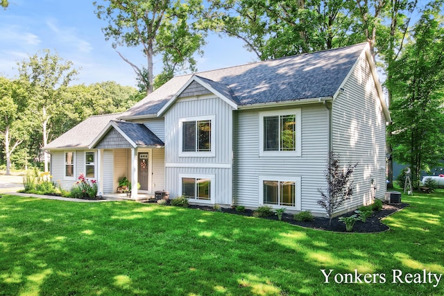 4005 Bullseye Ln, Dorr, MI 49323 - view of front of home with board and batten siding, roof with shingles, and a front lawn