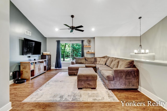 4005 Bullseye Ln, Dorr, MI 49323 - living room featuring lofted ceiling, wood finished floors, a ceiling fan, a chandelier, and recessed lighting