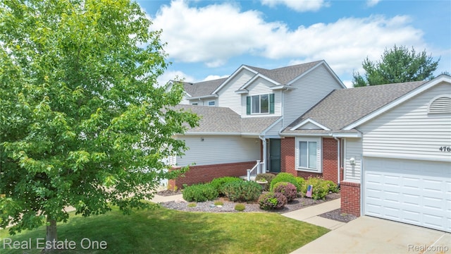 480 Hosta, Howell, MI 48843 - traditional-style house with roof with shingles, brick siding, a front lawn, an attached garage, and driveway