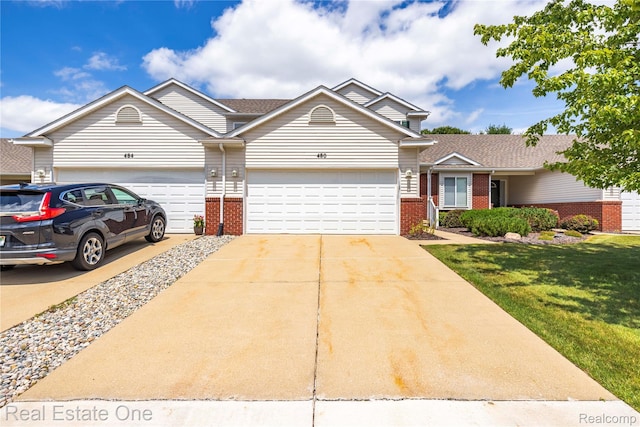 480 Hosta, Howell, MI 48843 - view of front of house with brick siding, driveway, an attached garage, and a front yard