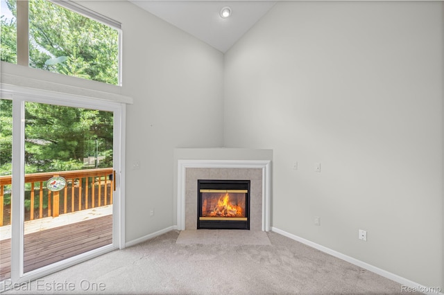 480 Hosta, Howell, MI 48843 - unfurnished living room featuring healthy amount of natural light, carpet floors, a tiled fireplace, and high vaulted ceiling