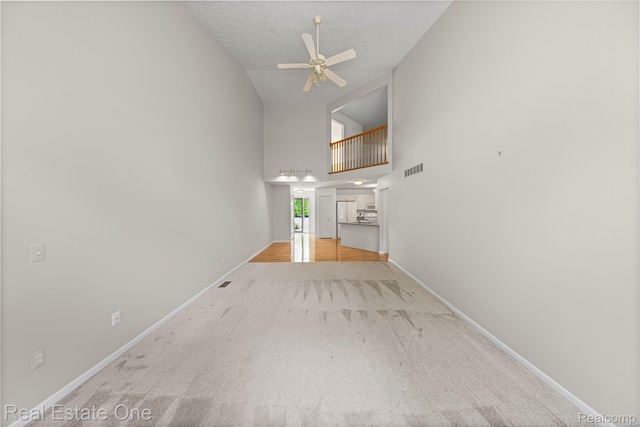 480 Hosta, Howell, MI 48843 - unfurnished living room featuring ceiling fan, carpet flooring, and high vaulted ceiling
