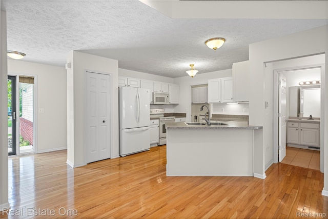 480 Hosta, Howell, MI 48843 - kitchen with white appliances, a peninsula, light wood-style floors, white cabinetry, and a textured ceiling