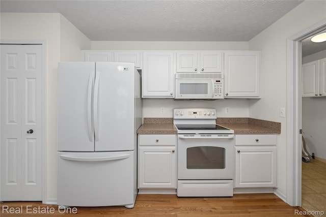 480 Hosta, Howell, MI 48843 - kitchen featuring white appliances, white cabinetry, dark countertops, light wood-style floors, and a textured ceiling