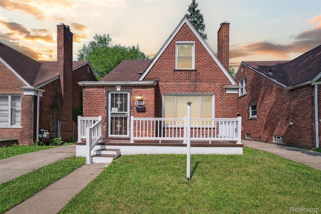 9585 Asbury Park, Detroit, MI 48227 - english style home with a chimney, a yard, brick siding, and covered porch