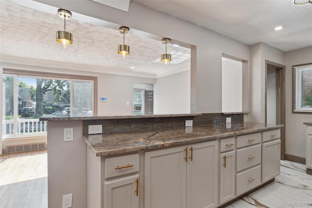 9585 Asbury Park, Detroit, MI 48227 - kitchen with a textured ceiling, healthy amount of natural light, hanging light fixtures, dark stone countertops, and light marble finish flooring