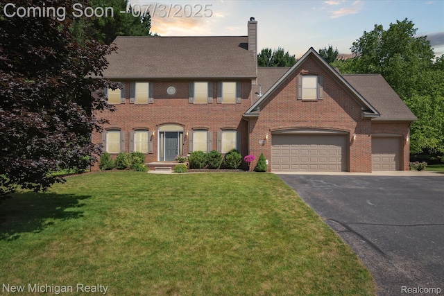 7155 Campbell Mills Ct, Brighton, MI 48116 - view of front facade featuring driveway, a chimney, brick siding, a front lawn, and a garage