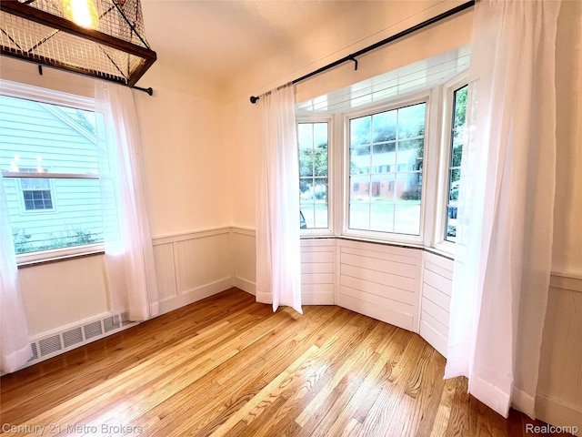 2122 Pierce St, Flint, MI 48503 - unfurnished room with healthy amount of natural light, wood finished floors, and a wainscoted wall