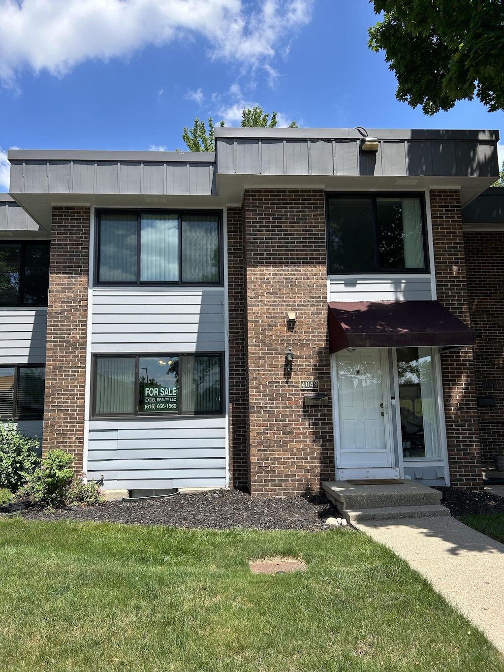 4049 S Norway St SE Unit 95, Grand Rapids, MI 49546 - view of front of home featuring brick siding and a front lawn