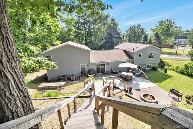 5885 Rockcroft Blvd, Clarkston, MI 48346 - back of property with a deck, a yard, and an outdoor living space with a fire pit