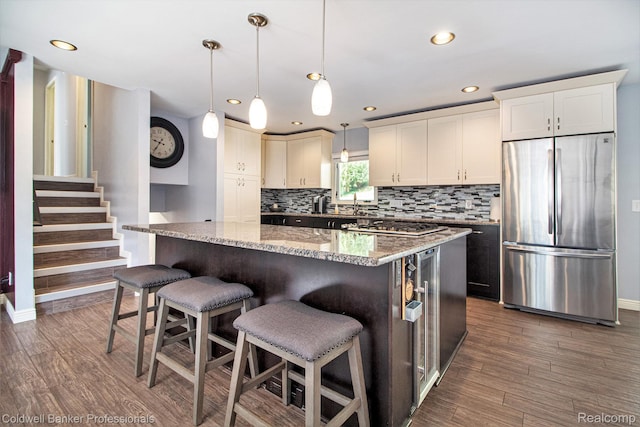 5885 Rockcroft Blvd, Clarkston, MI 48346 - kitchen with stainless steel appliances, recessed lighting, tasteful backsplash, light stone counters, and dark wood-type flooring