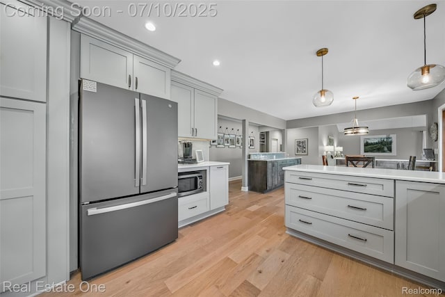 21653 Heatheridge Ln, Northville, MI 48167 - kitchen with stainless steel appliances, light countertops, gray cabinetry, light wood-style floors, and pendant lighting