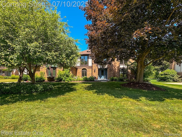21653 Heatheridge Ln, Northville, MI 48167 - view of property hidden behind natural elements featuring a front lawn and brick siding