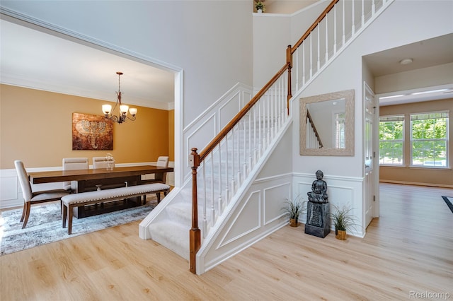 50042 Black Horse Ln, Canton, MI 48188 - staircase with wood finished floors, a chandelier, a decorative wall, a towering ceiling, and crown molding