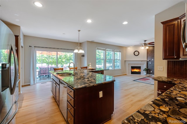 50042 Black Horse Ln, Canton, MI 48188 - kitchen with appliances with stainless steel finishes, light wood-style floors, ceiling fan, dark stone counters, and a tiled fireplace