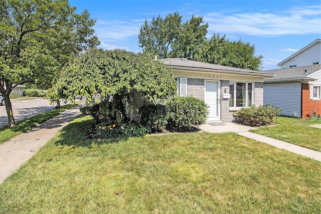 19263 Roger St, Melvindale, MI 48122 - obstructed view of property featuring a front lawn and brick siding