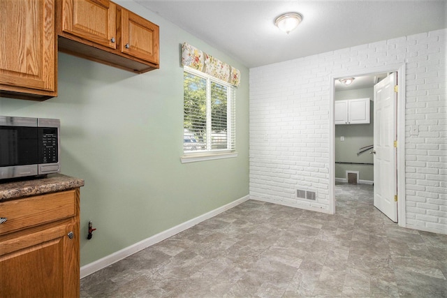 19263 Roger St, Melvindale, MI 48122 - unfurnished dining area featuring baseboards and brick wall