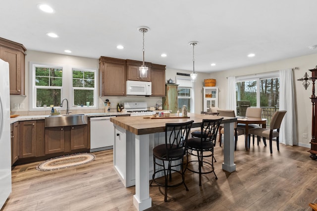 08311 W Shore Dr, Grand Junction, MI 49056 - kitchen featuring white appliances, recessed lighting, light wood-style floors, a kitchen island with sink, and a breakfast bar area