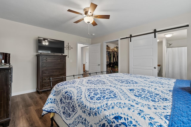 08311 W Shore Dr, Grand Junction, MI 49056 - bedroom featuring dark wood finished floors, a barn door, a walk in closet, ceiling fan, and a closet