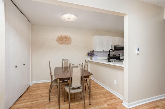 100 4th Ave, Tawas City, MI 48763 - dining area with light wood-style floors and baseboards