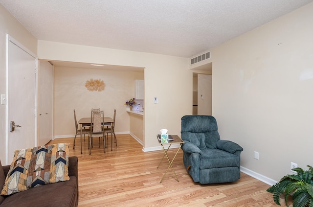 100 4th Ave, Tawas City, MI 48763 - living area with light wood-type flooring and a textured ceiling
