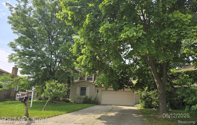 39713 Chaffer, Clinton Township, MI 48038 - view of property hidden behind natural elements featuring brick siding, a front yard, concrete driveway, and a garage