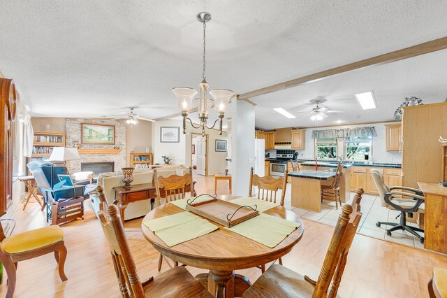 7900 Sunset Shores Dr, Canadian Lakes, MI 49346 - dining area featuring ceiling fan, a textured ceiling, a fireplace, and light wood-type flooring