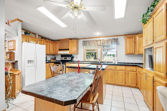 7900 Sunset Shores Dr, Canadian Lakes, MI 49346 - kitchen featuring white fridge with ice dispenser, stainless steel range with electric stovetop, exhaust hood, a center island, and ceiling fan