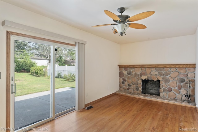 839 Judith St, Westland, MI 48186 - unfurnished living room with wood finished floors, a stone fireplace, and a ceiling fan