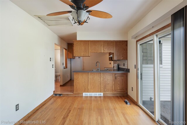 839 Judith St, Westland, MI 48186 - kitchen featuring light wood-style floors, ceiling fan, dark countertops, and a peninsula