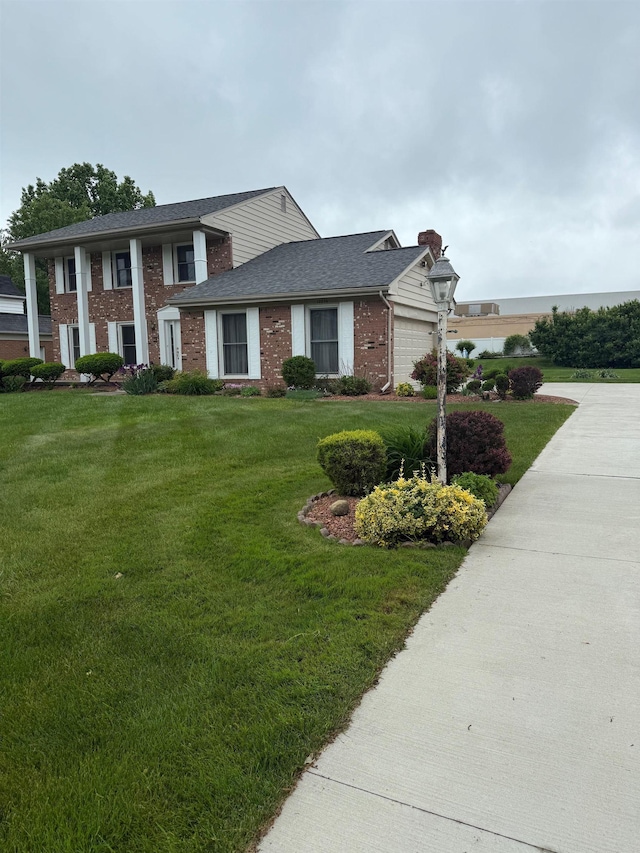 12806 Via Catherina Dr, Grand Blanc, MI 48439 - greek revival inspired property featuring brick siding, an attached garage, a front lawn, a chimney, and a shingled roof