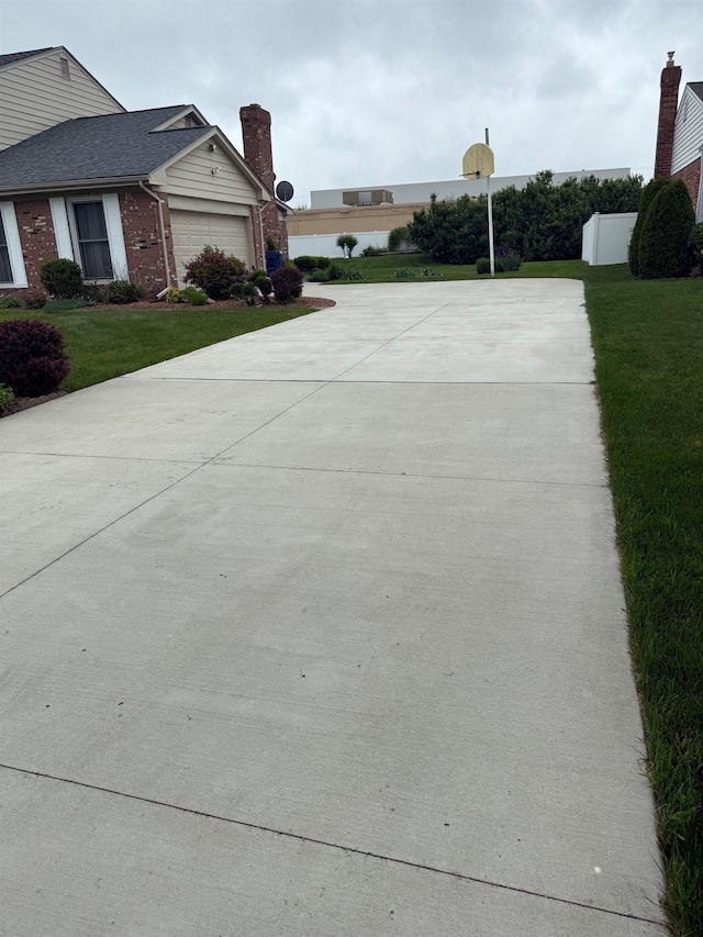 12806 Via Catherina Dr, Grand Blanc, MI 48439 - view of side of home featuring concrete driveway, a lawn, brick siding, and a garage