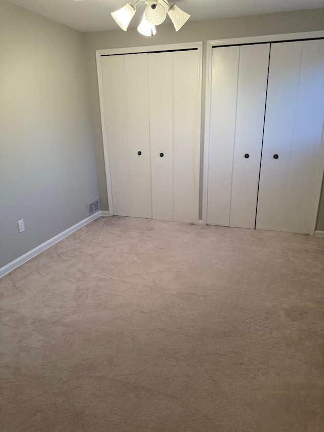12806 Via Catherina Dr, Grand Blanc, MI 48439 - unfurnished bedroom with multiple closets, light colored carpet, and ceiling fan