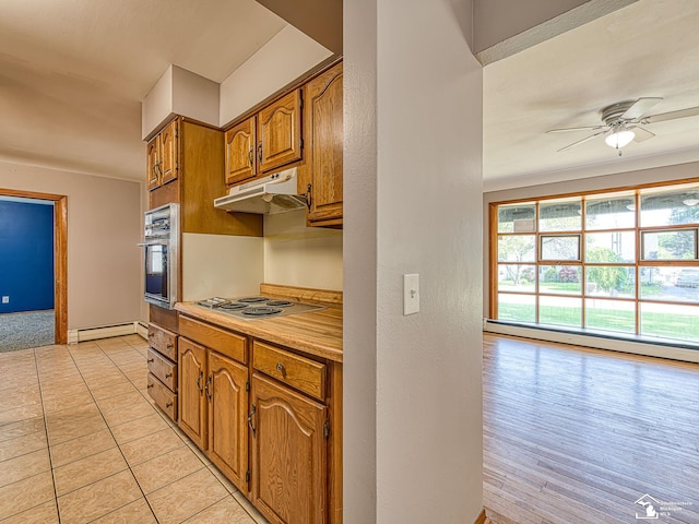 855 Mildred Ave, Temperance, MI 48182 - kitchen with under cabinet range hood, oven, brown cabinets, ceiling fan, and a baseboard radiator