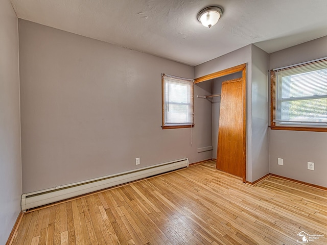 855 Mildred Ave, Temperance, MI 48182 - unfurnished bedroom with a baseboard heating unit, a closet, and hardwood / wood-style floors