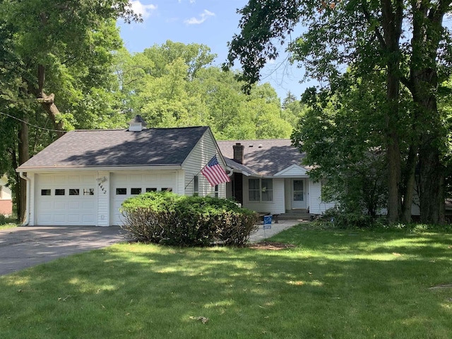 4442 Congdon Dr, Williamston, MI 48895 - view of front facade featuring a chimney, a front lawn, driveway, a garage, and roof with shingles