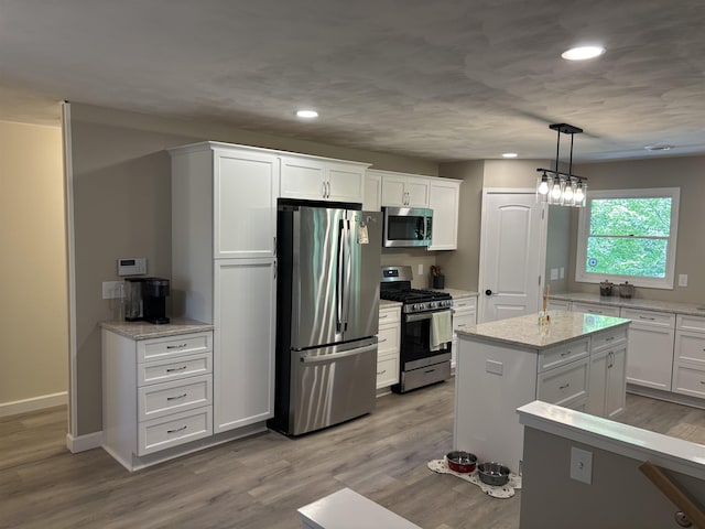 4442 Congdon Dr, Williamston, MI 48895 - kitchen with appliances with stainless steel finishes, white cabinetry, recessed lighting, wood finished floors, and pendant lighting