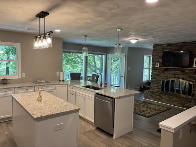 4442 Congdon Dr, Williamston, MI 48895 - kitchen with dishwasher, light wood finished floors, a center island, white cabinetry, and light stone counters