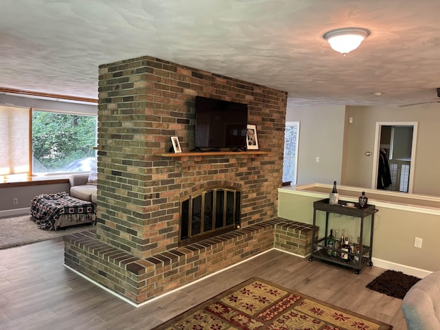 4442 Congdon Dr, Williamston, MI 48895 - living area featuring wood finished floors, a fireplace, and a textured ceiling