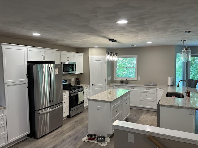 4442 Congdon Dr, Williamston, MI 48895 - kitchen featuring stainless steel appliances, white cabinets, a center island, wood finished floors, and recessed lighting