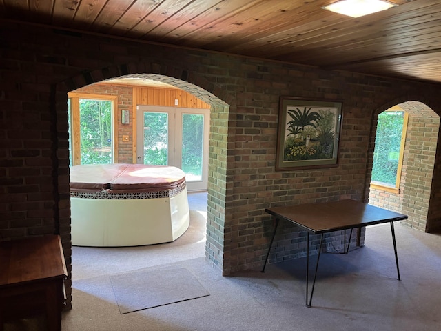 4442 Congdon Dr, Williamston, MI 48895 - carpeted dining space with wooden ceiling, plenty of natural light, brick wall, and arched walkways