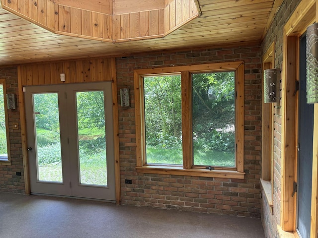 4442 Congdon Dr, Williamston, MI 48895 - doorway to outside with wooden ceiling, plenty of natural light, carpet, and brick wall