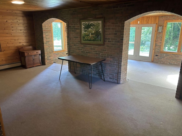 4442 Congdon Dr, Williamston, MI 48895 - unfurnished dining area with carpet, brick wall, a baseboard radiator, wooden ceiling, and wooden walls