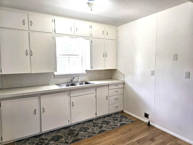 109 W Woodrow St, Fremont, MI 49412 - kitchen featuring wood finished floors, light countertops, and white cabinets